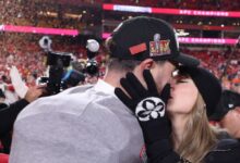 Taylor Swift kisses and hugs Travis Kelce on the field after the Chiefs win