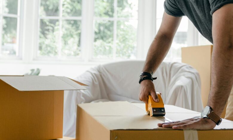 person taping a moving box