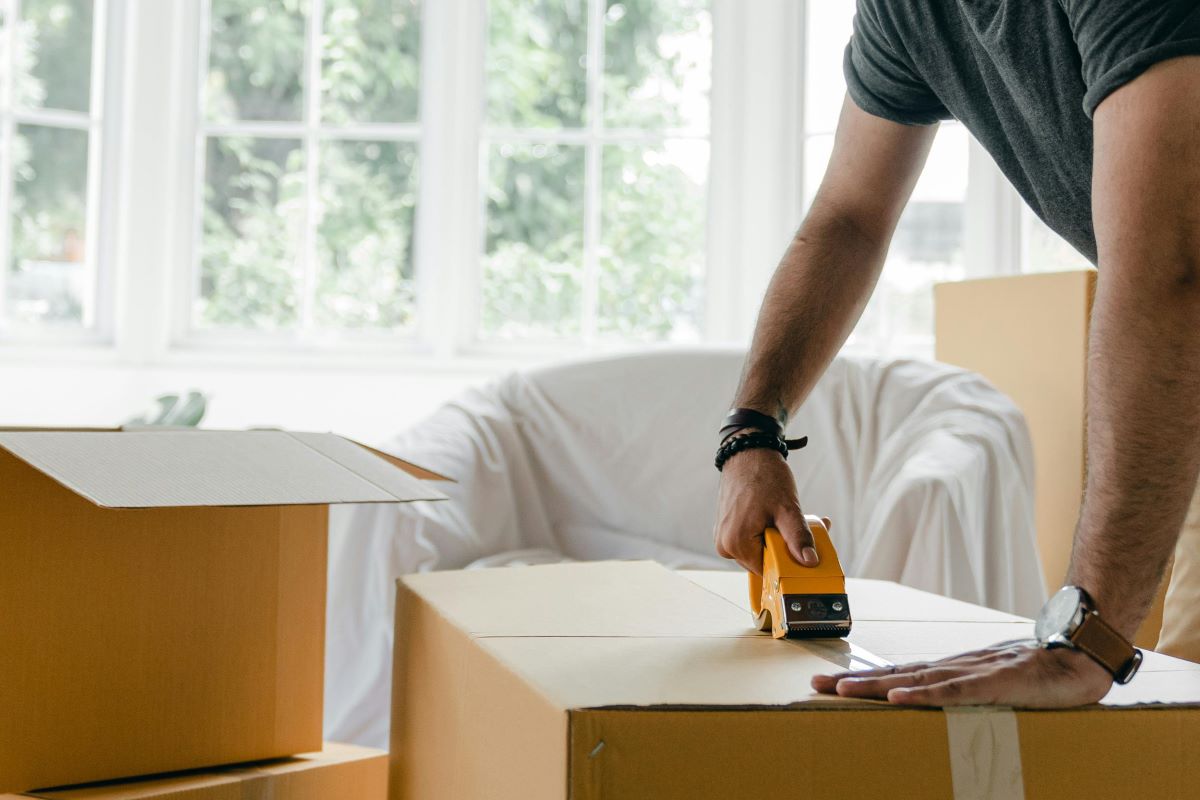 person taping a moving box