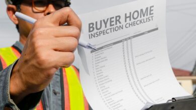 A man holder up a checklist that reads "buyer home inspection checklist"