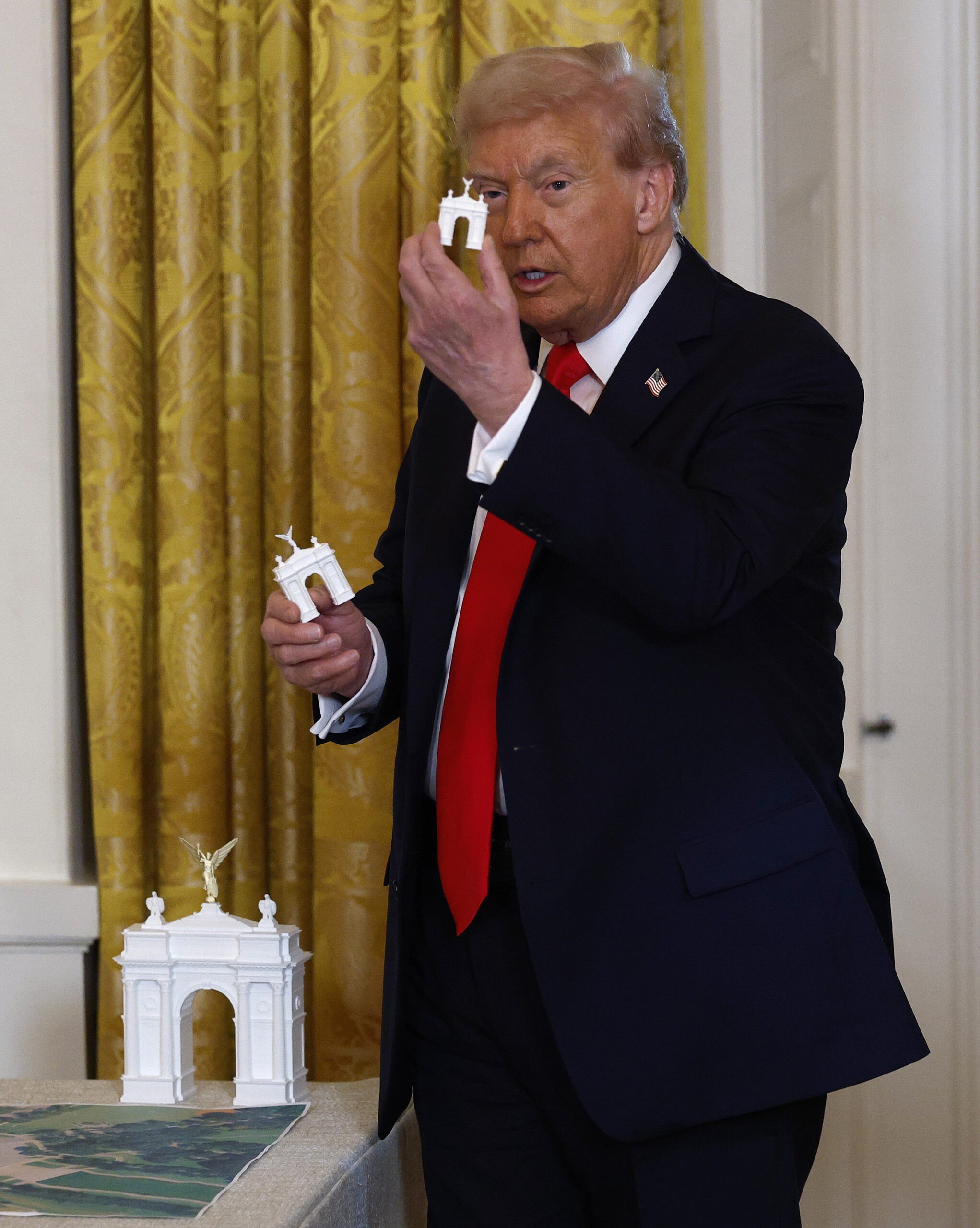 President Donald Trump holds models of a bow
