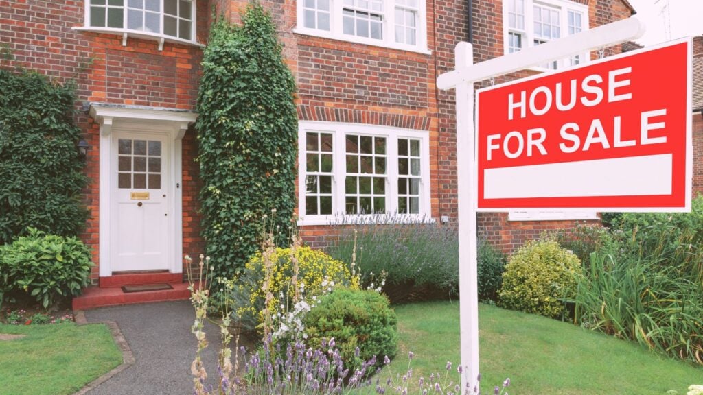 House with a "for sale" sign in the front yard
