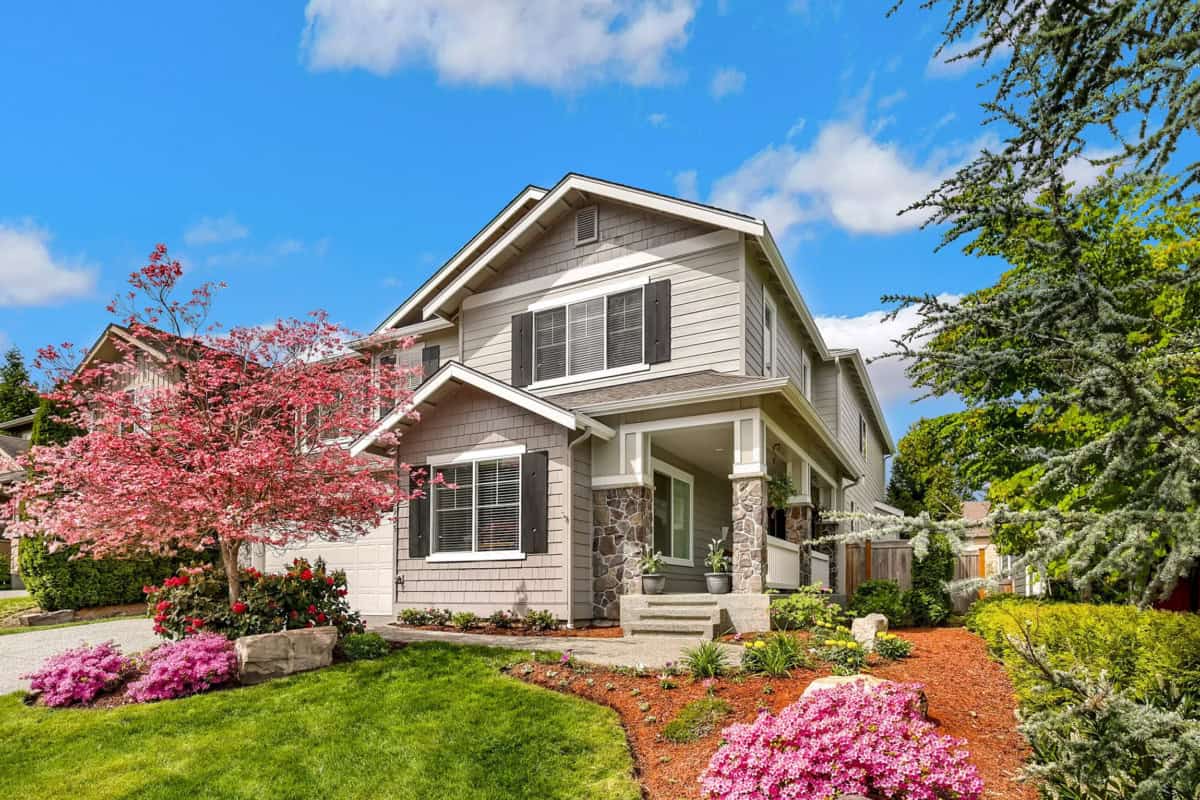 Tan house with flowers in yard