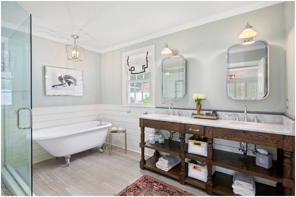 A bright bathroom with a tub and wood vanity