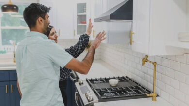 a man and woman inspect a kitchen